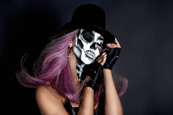 Piękny model w makijażu Halloween na czarnym tle. Seksowna kobieta w cylindrze i makijażu. Halloween makijaż koncepcja. - Zdjęcie, obraz