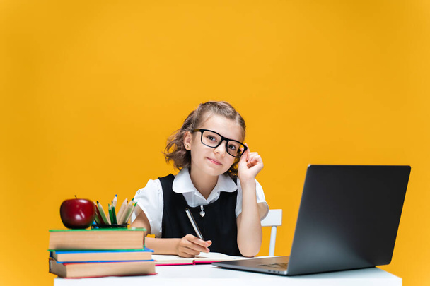 Caucasian schoolgirl in glasses sitting at laptop during online lesson. Distant School Learning. - Photo, Image