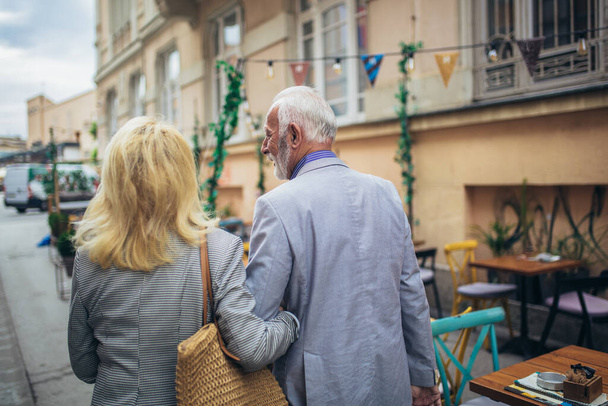 Mature married couple are walking through a city together. - Photo, Image