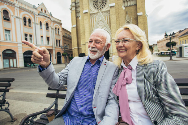 Seniorenpaar sitzt draußen auf Bank - Foto, Bild