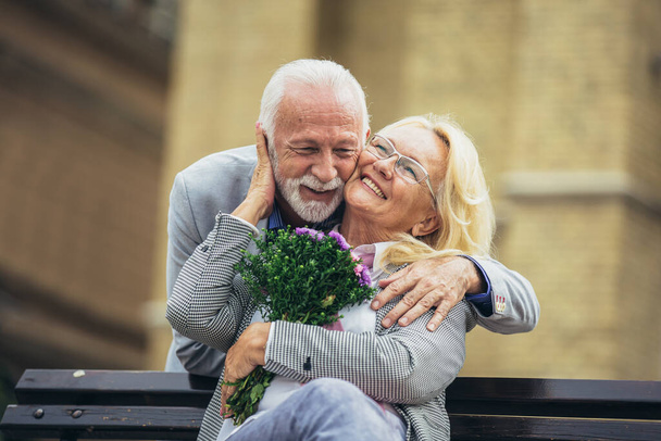 Homem de meia-idade romântico dando flores a sua esposa  - Foto, Imagem