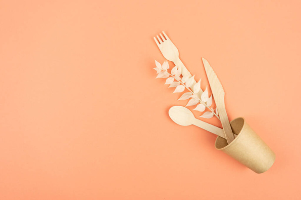 Eco Kraft utensilios de cocina. Copa de papel, comida rápida y cubiertos de madera sobre un fondo de color con lugar para el texto. - Foto, Imagen