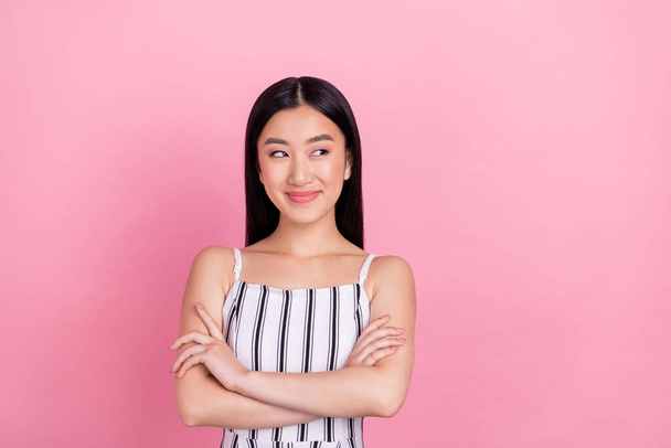 Photo of shiny dreamy young lady wear striped outfit smiling arms crossed looking empty space isolated pink color background - 写真・画像
