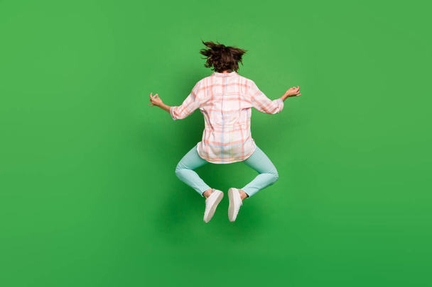 Full body back rear side spine view photo of young woman jump up yoga om sing asana meditate isolated on green color background - 写真・画像