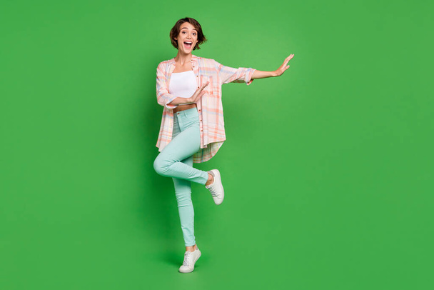Full body photo of funky young positive woman good mood hands dance enjoy weekend smile isolated on green color background - Photo, Image