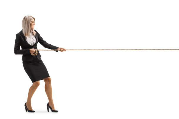 Полнометражный снимок молодой привлекательной бизнесвумен, дергающей веревку на белом фоне - Фото, изображение