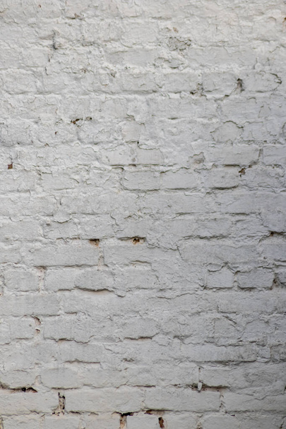 Stevige muur met witte bakstenen in vintage stijl als grijze stenen achtergrond of behang met stedelijke huisarchitectuur naadloos verouderd in rechthoek betegelde stenen textuur en moderne ruwe oppervlakte materiaal - Foto, afbeelding