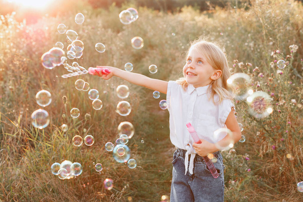 little girl and soap bubbles on a sunset walk - Photo, Image