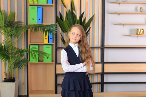 Młoda uczennica w klasie. Portret dziewczynki w szkolnym mundurze - Zdjęcie, obraz