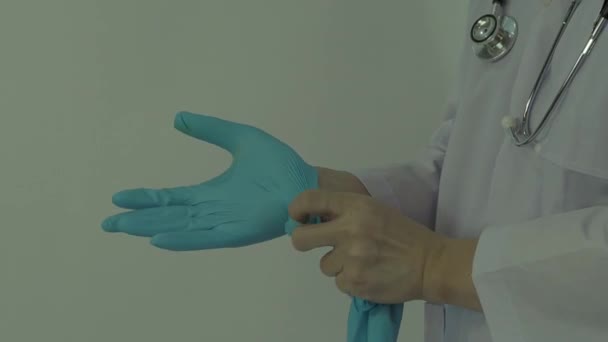 手袋をしてる。男性医師は青ゴムニトリル手手袋を着用してください。ドクの手袋をはめた映像。隔離された白い背景コピースペース。医療保護コロナウイルスパンデミックの概念. - 映像、動画