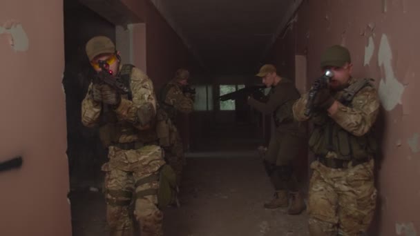 Escuadrón antiterrorista caminando por el pasillo del edificio, revisando habitaciones - Imágenes, Vídeo
