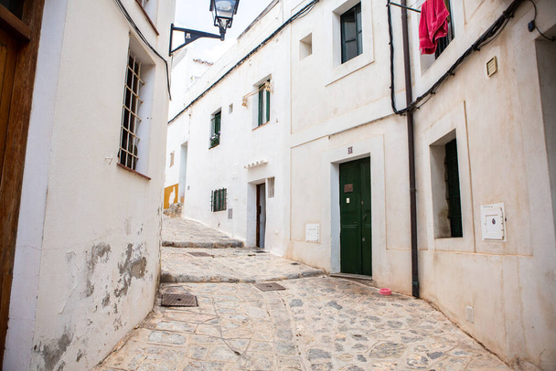 The architecture of the island of Ibiza. A charming empty white street in the old town of Eivissa.  - Foto, afbeelding
