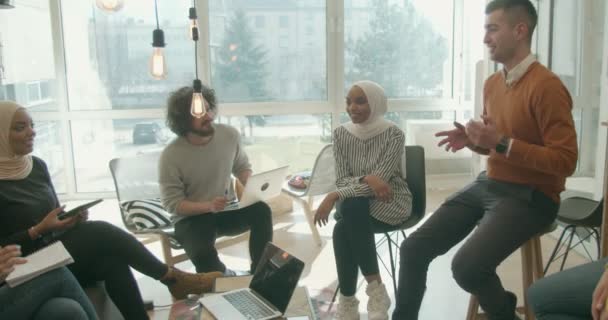 Grupo de compañeros de trabajo multirraciales que comparten las ideas que tienen para la empresa en su oficina - Metraje, vídeo