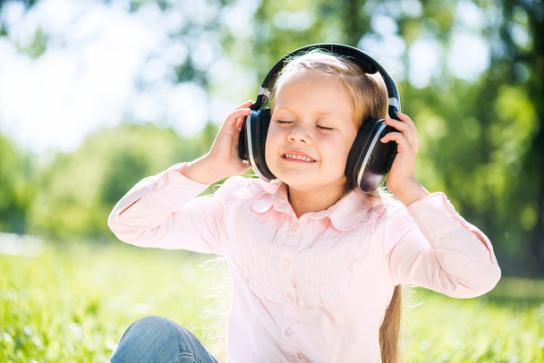 Girl in summer park listening music - Fotografie, Obrázek