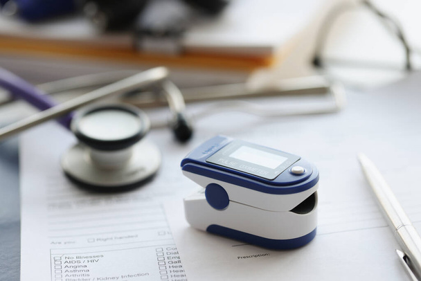 Pulse oximeter used to measure heart rate and oxygen levels on table - Foto, immagini