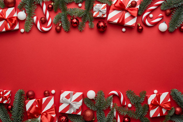 Fond de Noël avec un cadre décoré de cadeaux de fête, de cannes à bonbons et de branches de sapin - Photo, image