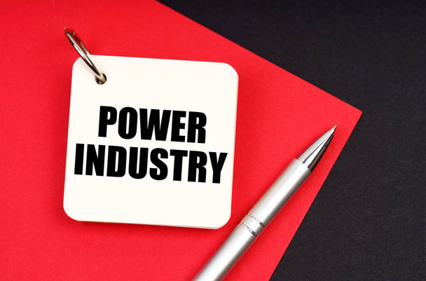 Industry and business concept. On a black and red background lies a pen and a notebook with the inscription - Power Industry - Foto, immagini