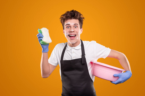 Cheerful man with sponge and basin - Foto, Imagen