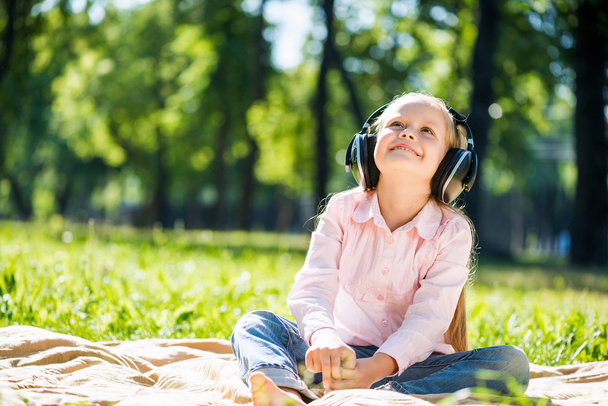 Girl in summer park listening music - Fotó, kép