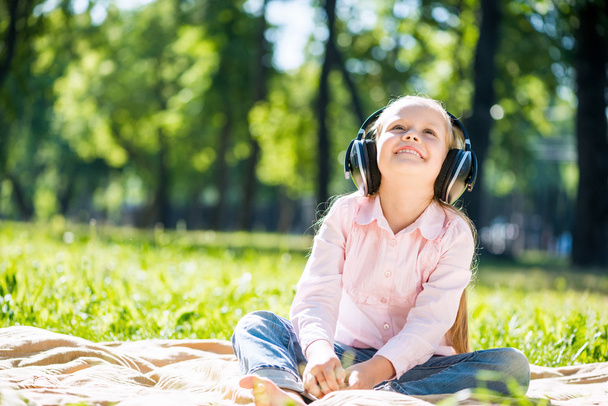 Girl in summer park listening music - Foto, Imagen