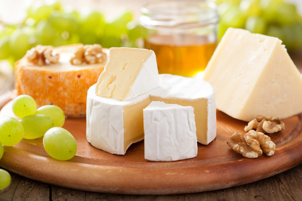 カマンベール、チェダー チーズ、ブドウ、蜂蜜とチーズの盛り合わせ - 写真・画像