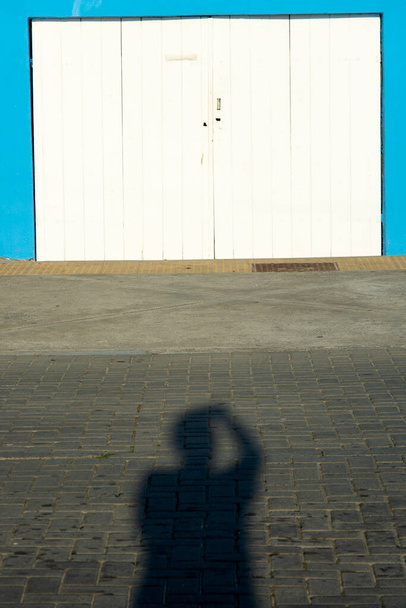 Salvador, Bahia, Brazil - June 17, 2021: Shadow in the street of the photographer himself in the streets of the Barra neighborhood in the late afternoon in Salvador, Bahia. - Fotó, kép