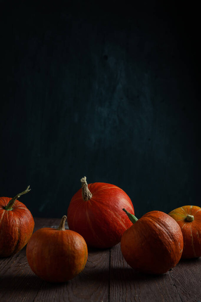 Pumpkins in a row on wooden table. Copy space. Vertical orientation. - Фото, изображение