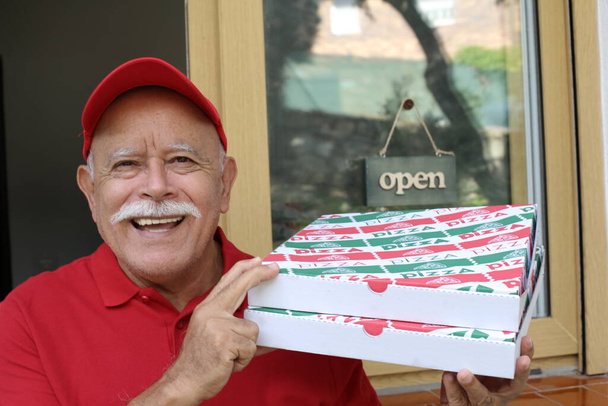 ritratto ravvicinato del bell'uomo anziano che tiene due scatole della pizza mentre consegna la pizza - Foto, immagini