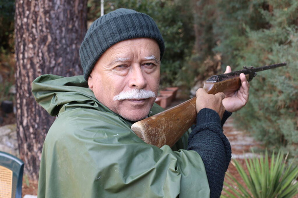close-up retrato de bonito caçador sênior com rifle na floresta - Foto, Imagem
