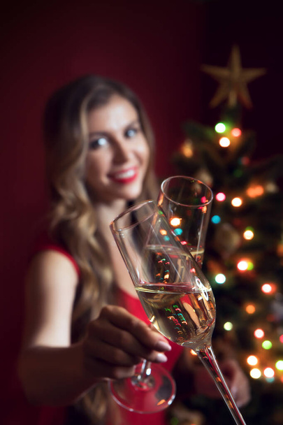 ritratto di bella donna in abito rosso con champagne in ambiente natalizio - Foto, immagini