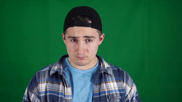 man twists his finger near his head on a green screen. green background chromakey - Footage, Video