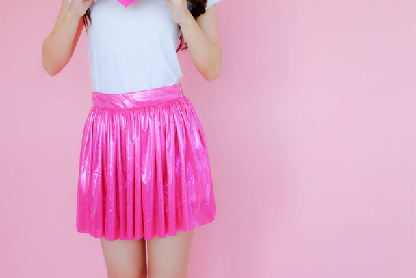 beautiful asian female wearing white T-shirt and pink skirt on pink background - Photo, image