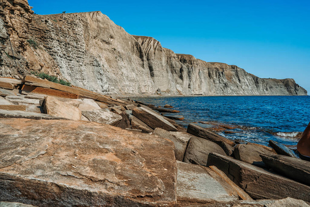  Μια βραχώδης παραλία φτιαγμένη από φυσικές ορθογώνιες πέτρες στην Κριμαία, ένα ζοφερό άψυχο τοπίο - Φωτογραφία, εικόνα