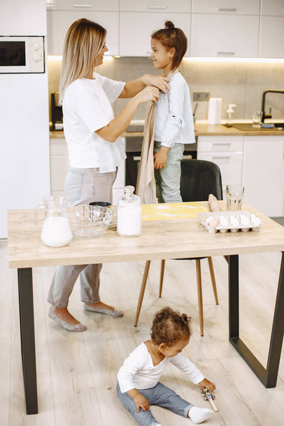 Amare la giovane madre o la tata insegnare al bambino a preparare il cibo a casa cucina - Foto, immagini