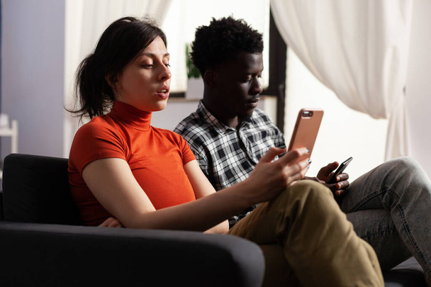 Close up of modern interracial couple using smartphones - Photo, image