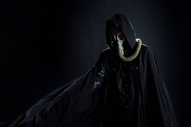 post-apocalyptic character, a scary story, a concept character in a gas mask and a black coat - Foto, Bild