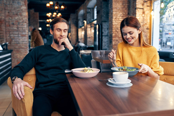 jong stel zitten in een restaurant chatten dating - Foto, afbeelding