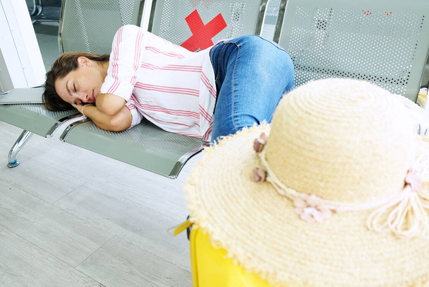 Кавказька мандрівниця спить у пасажирах, чекаючи на літак в аеропорту. Джоні і подорожі в ділову подорож з відпусткою Під час епідемії COVID19. - Фото, зображення