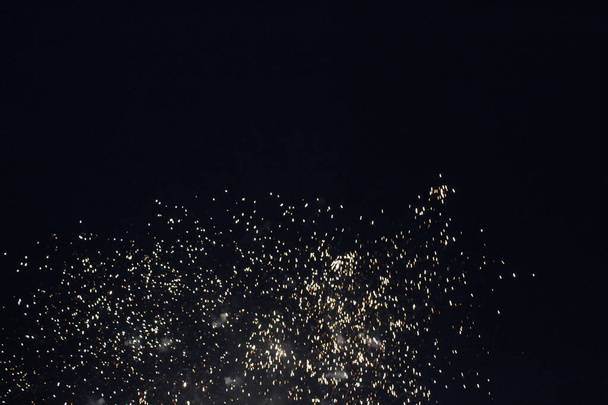 Розетка цветы искры белый салют фейерверк на черном темном фоне праздник праздничная атмосфера Новый год День независимости Рождество. - Фото, изображение