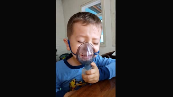 Een jongen van 3 jaar wordt behandeld met een vernevelaar. - Video