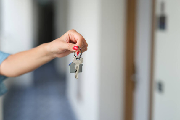 Nainen käsi punainen manikyyri tilalla talon avaimet lähikuva - Valokuva, kuva