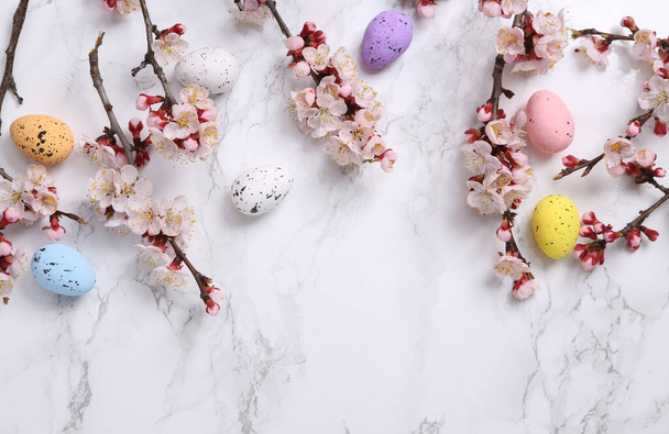 Húsvét kompozíció. Húsvét színes tojás márvány háttér gyönyörű virágzó ágak - Fotó, kép