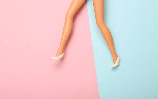 Doll woman legs in high heel shoes on a blue pink pastel background. Minimalism fashion concept - Fotografie, Obrázek