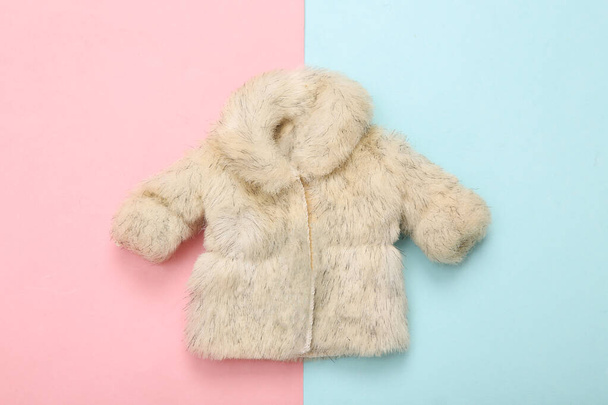 Doll fur coat on a blue-pink pastel background. Minimalism fashion layout. Top view. Flat lay - Photo, Image