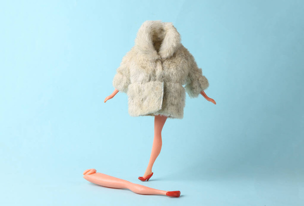Maniquí de muñeca en abrigo de piel caliente sobre un fondo azul. Minimalismo tiro de moda. Arte conceptual - Foto, imagen