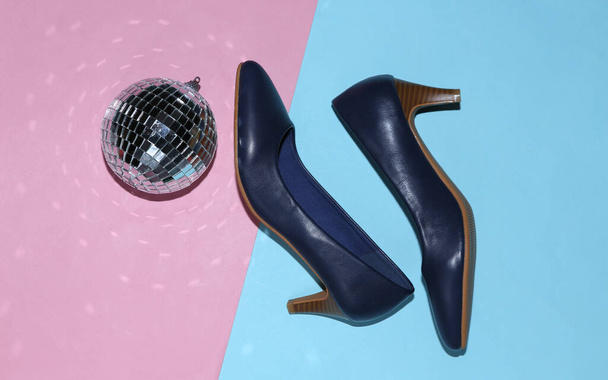 Bola de discoteca con zapatos sobre fondo azul-rosa. Vista superior. Acostado. Concepto de partido minimalismo - Foto, imagen
