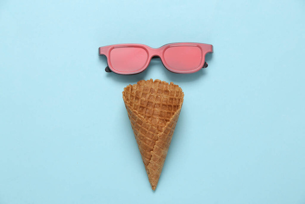 Óculos cor de rosa com cone de waffle de sorvete em fundo azul. Conceito de festa mínima. Layout criativo - Foto, Imagem