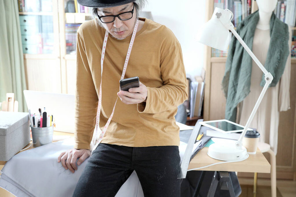 The senior Asian designer working in the studio. - Foto, afbeelding