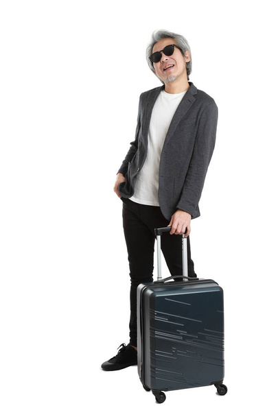 The senior Asian businessman standing with luggage on the white background. - Foto, Imagem