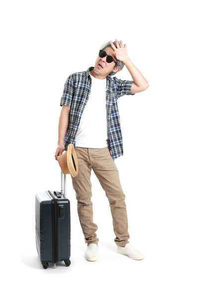 The senior Asian man standing with luggage on the white background. - Foto, imagen